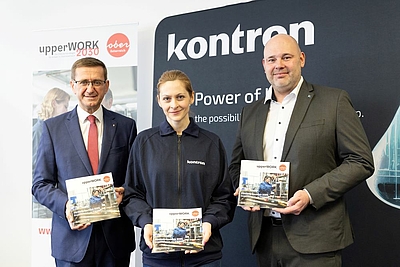 V. l.: Wirtschafts-Landesrat Markus Achleitner, Milana Belic (Mitarbeiterin der Kontron Austria GmbH und Absolventin des upperWORK-Programms Digital Pioneers), DI Stephan Niederhauser (Geschäftsführer Kontron Austria) mit der neuen upperWORK Förderbroschüre 2025 